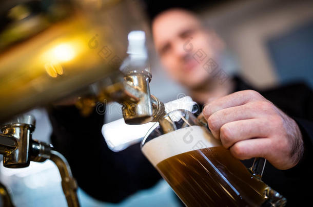 啤酒厂用啤酒泵在啤酒杯中灌装啤酒