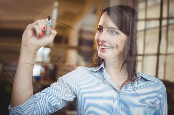 女商人微笑着用记号笔在玻璃上写字