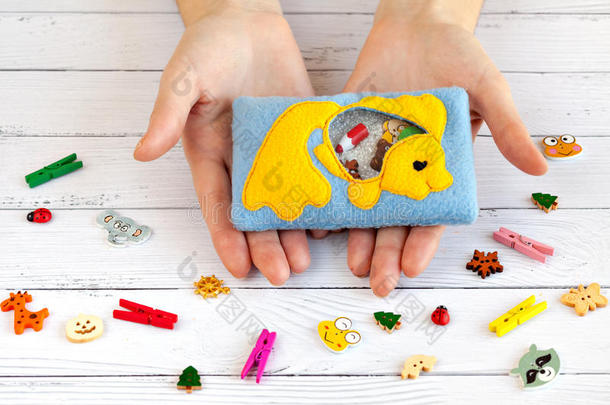儿童用彩色羊毛制成的用于运动发育的玩具。装有黄鱼的塑料珠和小雕像的袋子