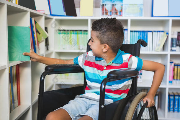 残疾男孩从图书馆的书架上挑选一本书