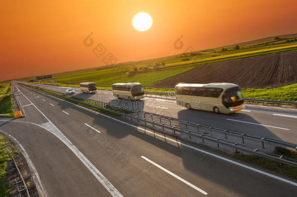 日落时，高速公路上一排快速<strong>旅行巴士</strong>