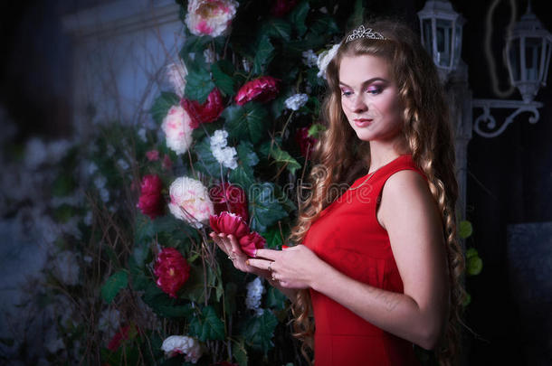 童话<strong>故事</strong>。 穿着<strong>红色</strong>连衣裙的美丽公主坐在一个神秘的花园里
