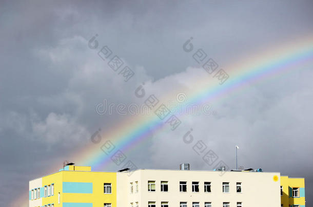 明亮的多色宽阔的彩色<strong>彩虹</strong>在暴风<strong>雨后</strong>在灰色的天空上的城镇房屋