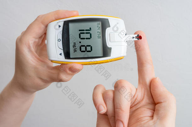 糖尿病患者持有血糖仪并测量血糖水平