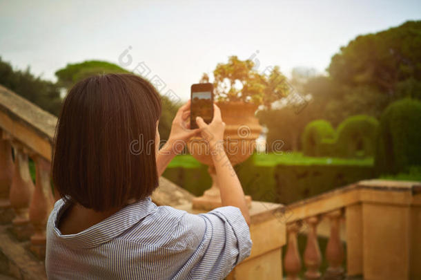 女孩在公园用智能<strong>手机</strong>拍照