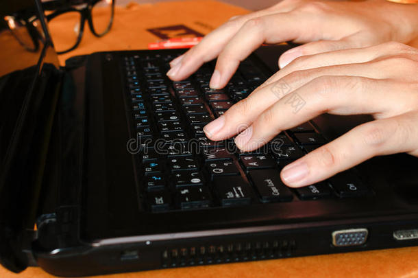 关闭妇女在家庭办公室工作，手指打字使用触摸短信在电脑笔记本电脑键盘