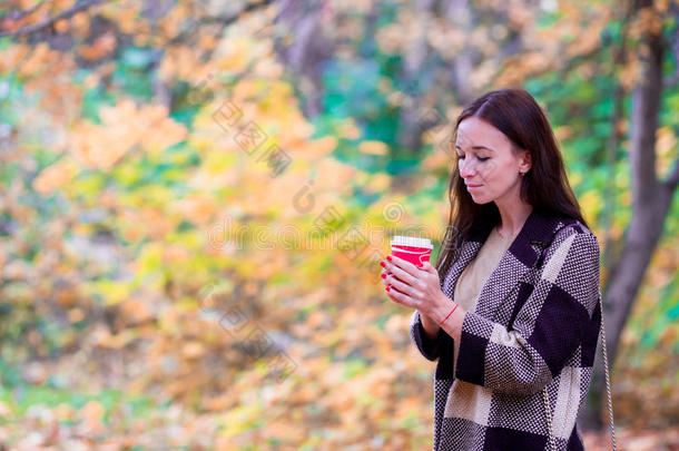 美丽的女人在秋天的公园里<strong>喝</strong>咖啡。 咖啡要<strong>喝了</strong>