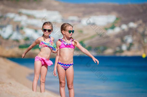 可爱的小女孩在海滩度<strong>假期</strong>间玩得很<strong>开心</strong>。 两个孩子在希腊度假