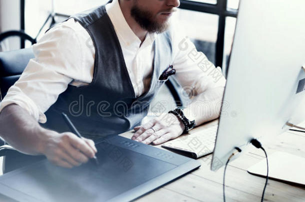特写胡须创意总监工作图纸数字平板电脑桌面电脑木桌。时尚的年轻人穿着