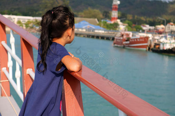 一个女孩站在海里的船上。