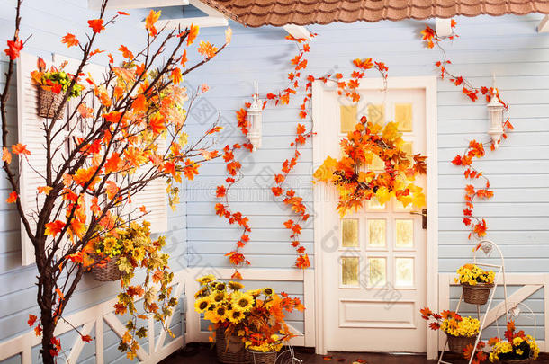 舒适的院子里有蓝色的墙壁和白色的窗户，在秋天的季节。 <strong>到处都是</strong>黄色的叶子。