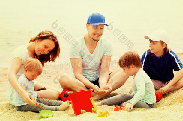 快乐的父母和孩子们在玩沙子