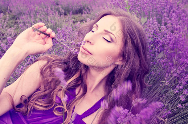 穿着紫色连衣裙的漂亮年轻女人穿着薰衣草的裙子做梦