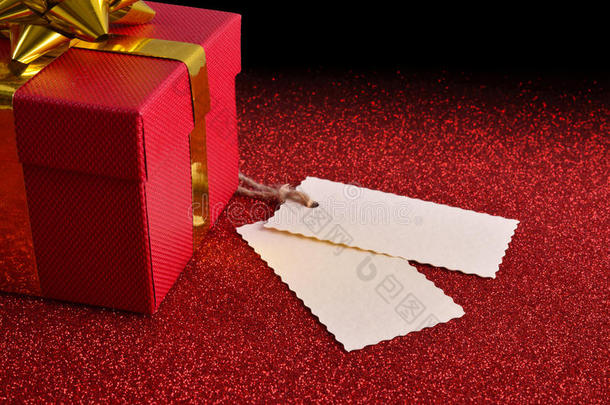 礼物与两个标签上的鲜红纹理的桌子高架