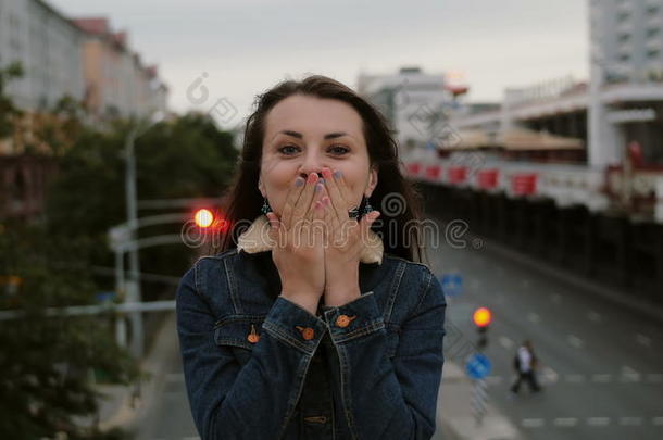 开朗，快乐，微笑的女孩站在桥上，送吻，玩得开心，看着相机。 4k