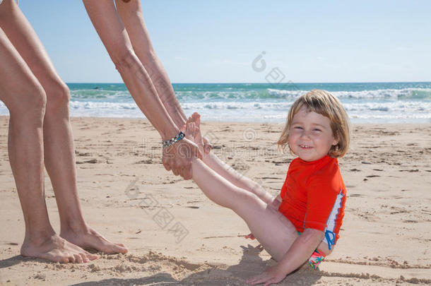 有趣的孩子在沙滩上被女人<strong>滑倒</strong>了