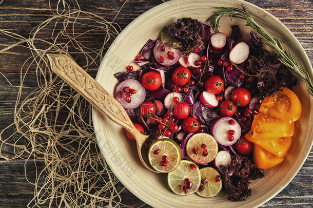 新鲜水果和蔬菜沙拉放在盘子里，或者放在木制桌子上，上面有<strong>西红柿</strong>、卷心菜、石榴、石灰、<strong>萝卜</strong>