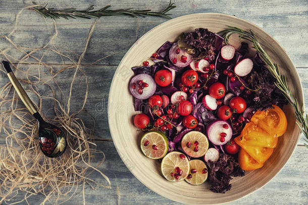 新鲜水果和蔬菜沙拉放在盘子里，或者放在木制桌子上，上面有<strong>西红柿</strong>、卷心菜、石榴、石灰、<strong>萝卜</strong>