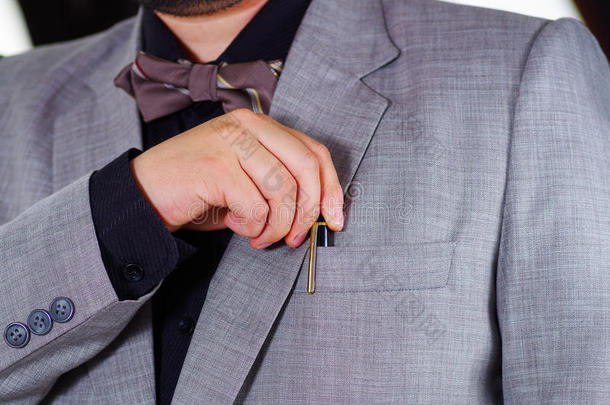 特写男子的胸部区域穿着正式的西装和领带，把钢笔放在夹克口袋里，男人穿衣服的概念