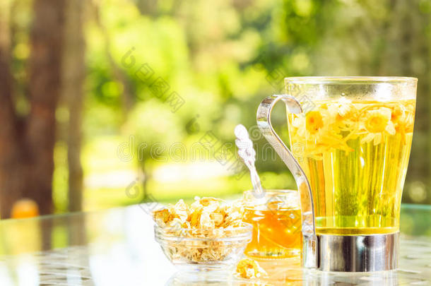 凉茶的概念。 在杯子里放迷彩茶。 绿色草地