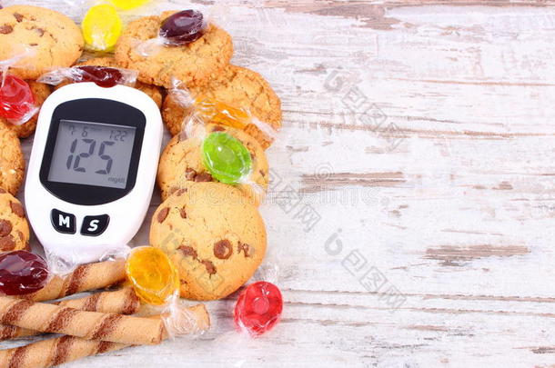 血糖仪和彩色糖果与饼干，糖尿病，减少吃糖果