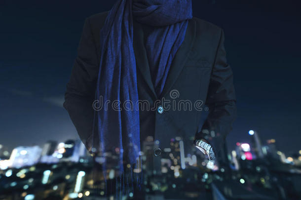 商人手在口袋里的休闲西装与多曝光离焦城市在夜间背景