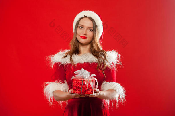 <strong>圣诞</strong>节，<strong>圣诞</strong>节，冬天，幸福的概念-微笑的女人戴着<strong>圣诞</strong>老人的帽子，带着礼品盒，<strong>红色背景</strong>