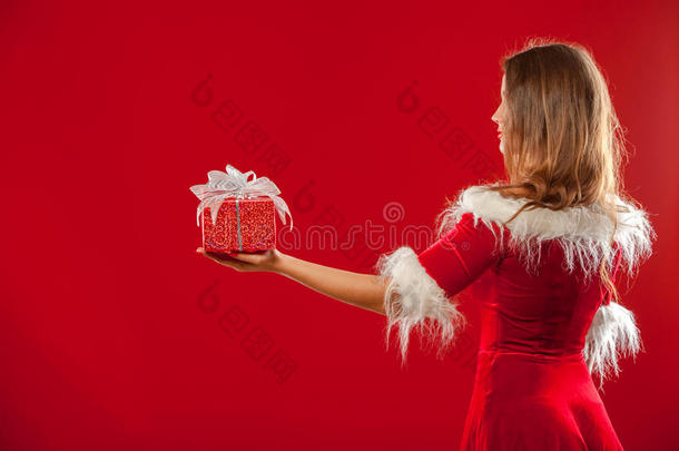 <strong>圣诞</strong>节，<strong>圣诞</strong>节，冬天，幸福的概念-微笑的女人戴着<strong>圣诞</strong>老人的帽子，带着礼品盒，<strong>红色背景</strong>。