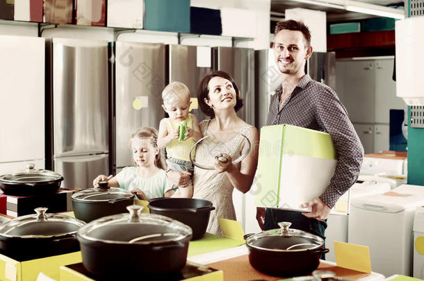 一对夫妇和两个孩子在家<strong>电商店</strong>挑选新的厨具