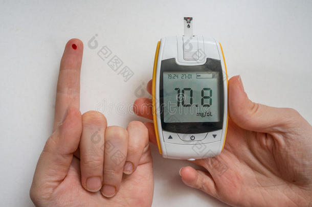 糖尿病患者使用血糖仪检查血糖水平。