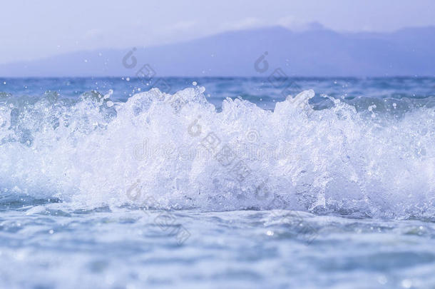蓝色的海洋或海洋，美丽的波浪，水滴，天空，山脉