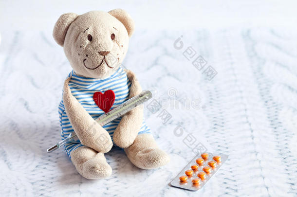 <strong>儿童</strong>软玩具泰迪熊与药丸测量水银玻璃温度计的温度。<strong>儿童</strong>疾病。