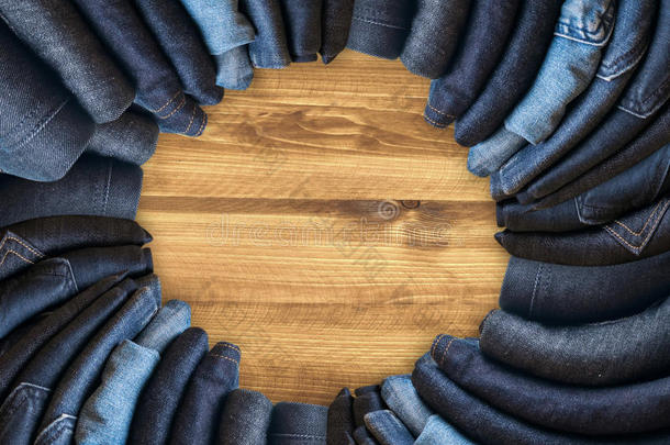 棕色木制背景上的蓝色牛仔裤和蓝色牛仔裤牛仔色