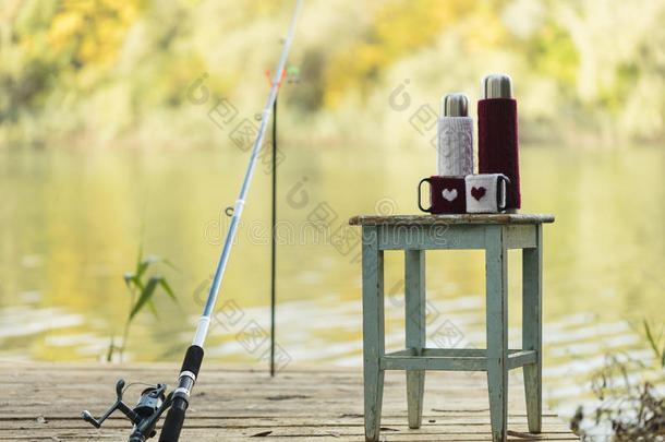 在河里钓鱼。 钓鱼竿和一个热水瓶在针织