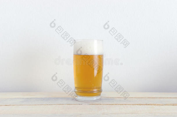 一杯<strong>冰镇啤酒</strong>在一张白色的木桌上。