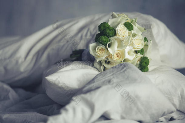 美丽的婚礼花束躺在床上的垫子上
