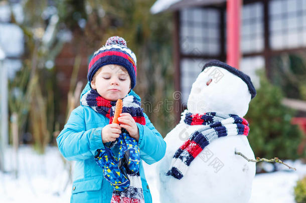 有趣的<strong>男孩</strong>在冬天的户外<strong>堆雪人</strong>