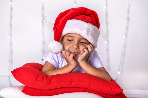 一个小孩子穿着圣诞老人的衣服，期待着圣诞节和新年