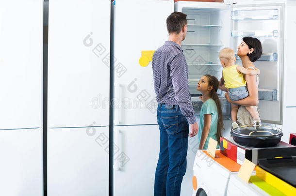 一家四口在家电商店买新冰箱
