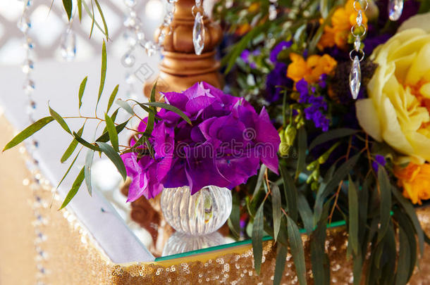 插花装饰紫色的婚礼桌。 th