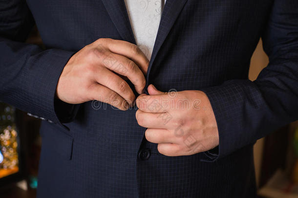 正确的按钮在夹克，双手特写，穿衣，男人的风格，纠正袖子
