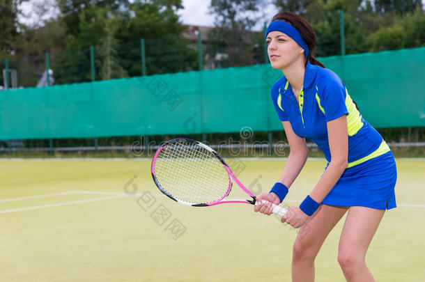 自信的年轻女子在<strong>网球场</strong>上打网球