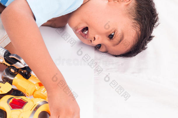 孩子亚洲小男孩躺在地板上玩玩具