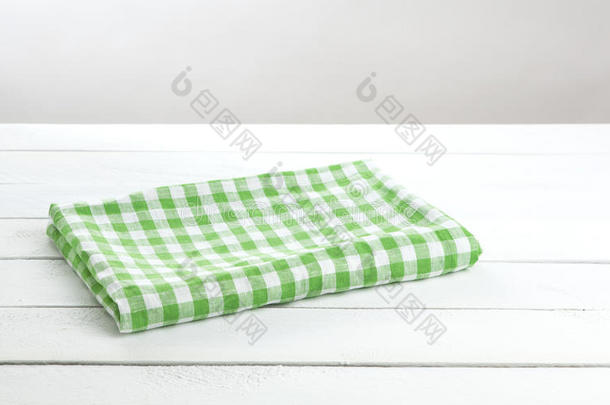 绿色<strong>折叠</strong>桌布在白色<strong>桌子</strong>背景上，用于产品蒙太奇