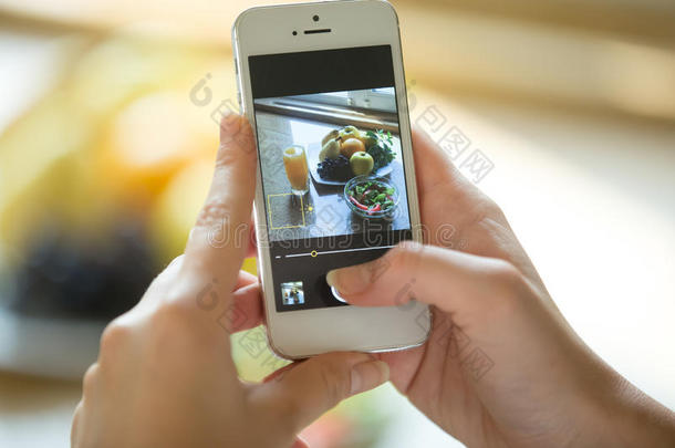 手拿着屏幕上有食物图片的手机