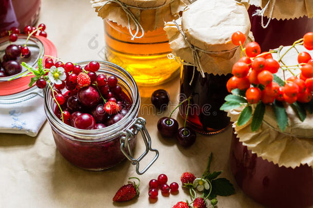 厨房桌子上的水果蜜饯和生草莓、樱桃、罗纹浆果