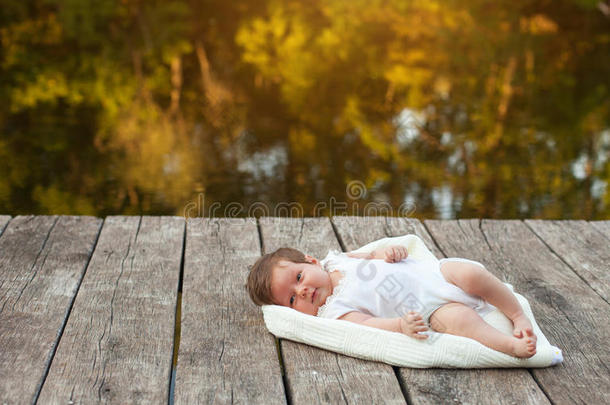 婴儿躺在河边码头的毯子上