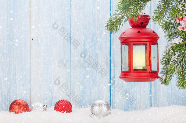 雪中冷杉树枝上的圣诞蜡烛灯笼