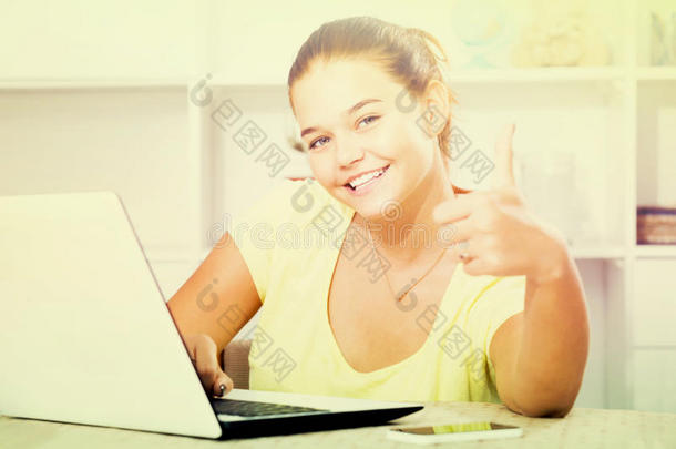 女孩学校的<strong>学生</strong>坐在笔记本电脑上，竖起<strong>大拇指</strong>