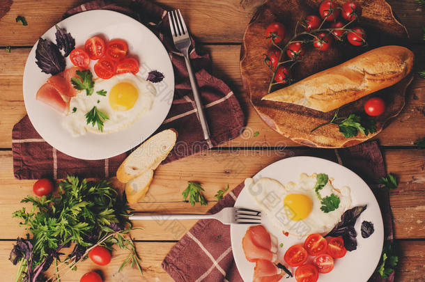 煎鸡蛋配西红柿，罗勒和意大利火腿，桌子为舒适的早餐